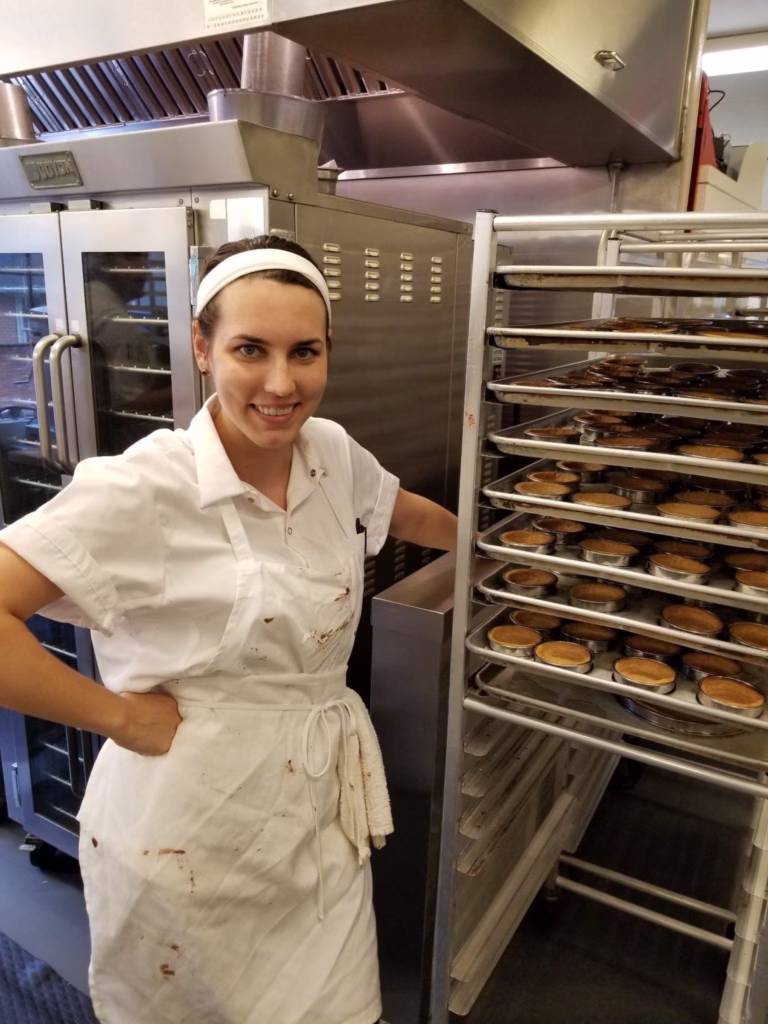 A professional organizer showing off freshly baked tart shellsfrom her time working in a French bakery