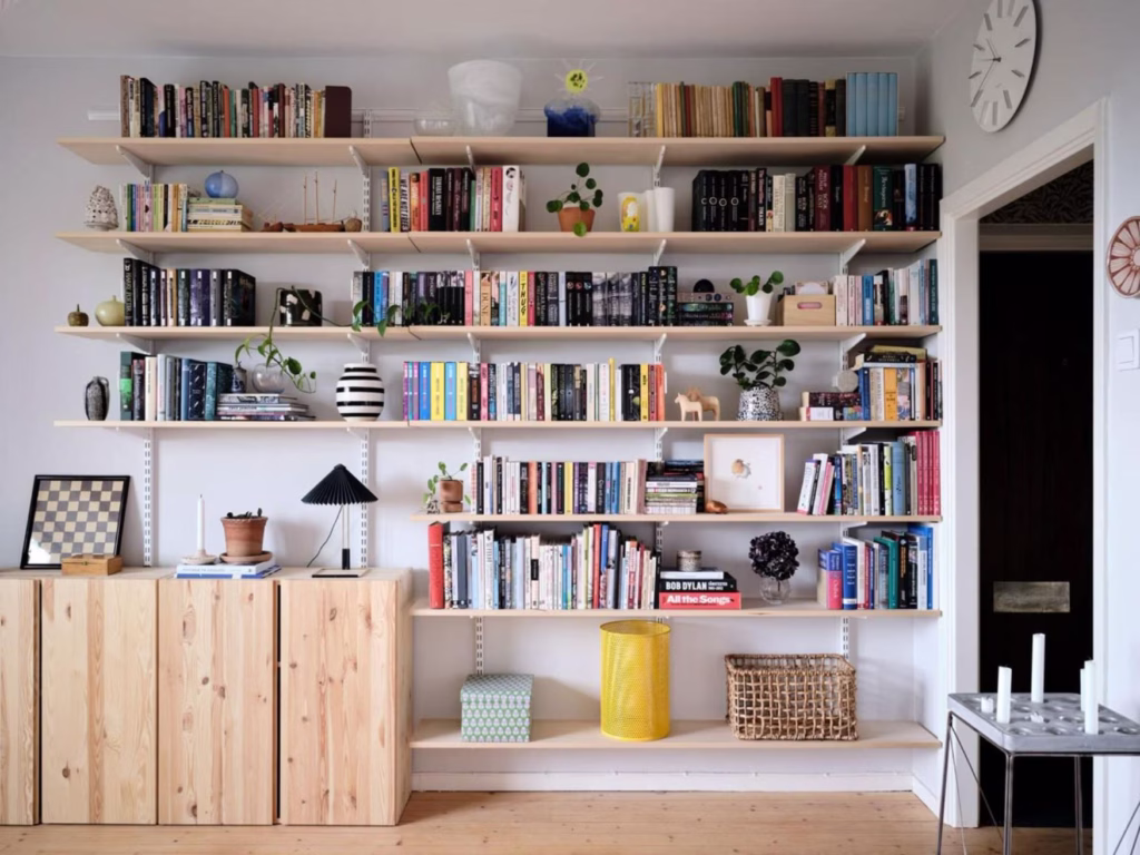 a multipurpose living room makes space for everything a family needs through wall shelving and cabinets